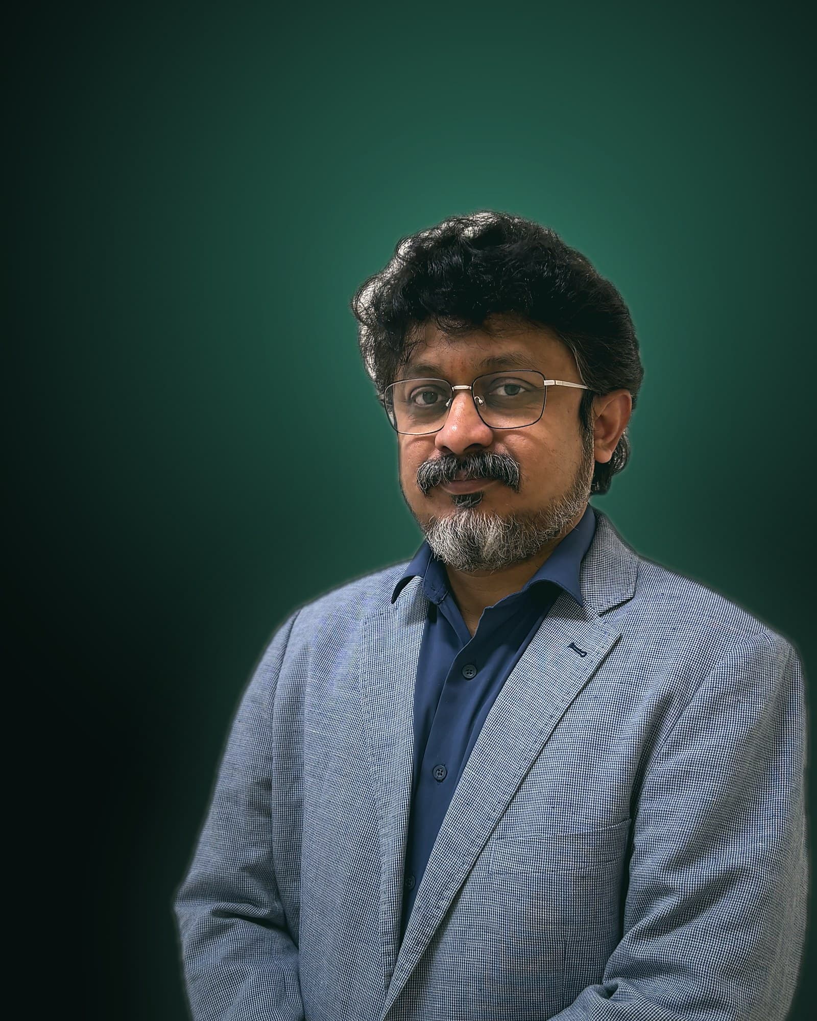 Dr. Amol Gawande standing with arms folded, studio portrait